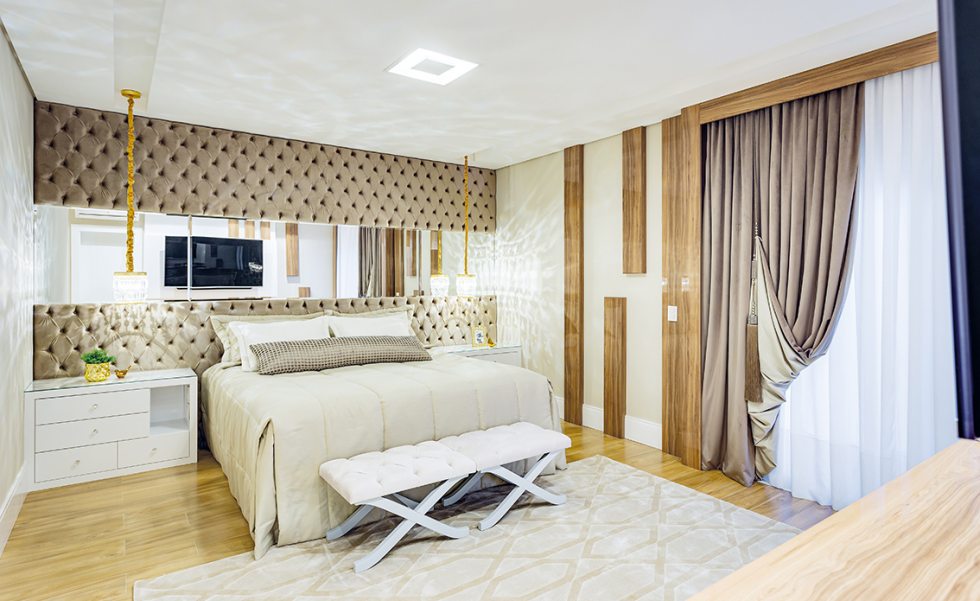 As tonalidades acolhedoras da madeira aparecem tanto no piso (Pastilhart) quanto em detalhes trabalhados nas paredes e em volta das janelas