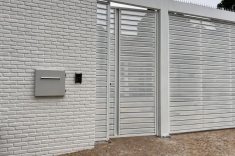 Locker inteligente instalado no muro, permitindo que a encomenda seja depositada pela rua e retirada pelo lado interno da residência.