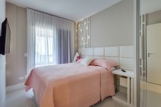 O quarto da menina tem cabeceira feita sob medida e arandelas embutidas no painel