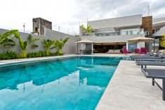 Na área da piscina foi criada uma área de estar externa equipada com uma mesa de centro que pode ser lareira ou champagneira
